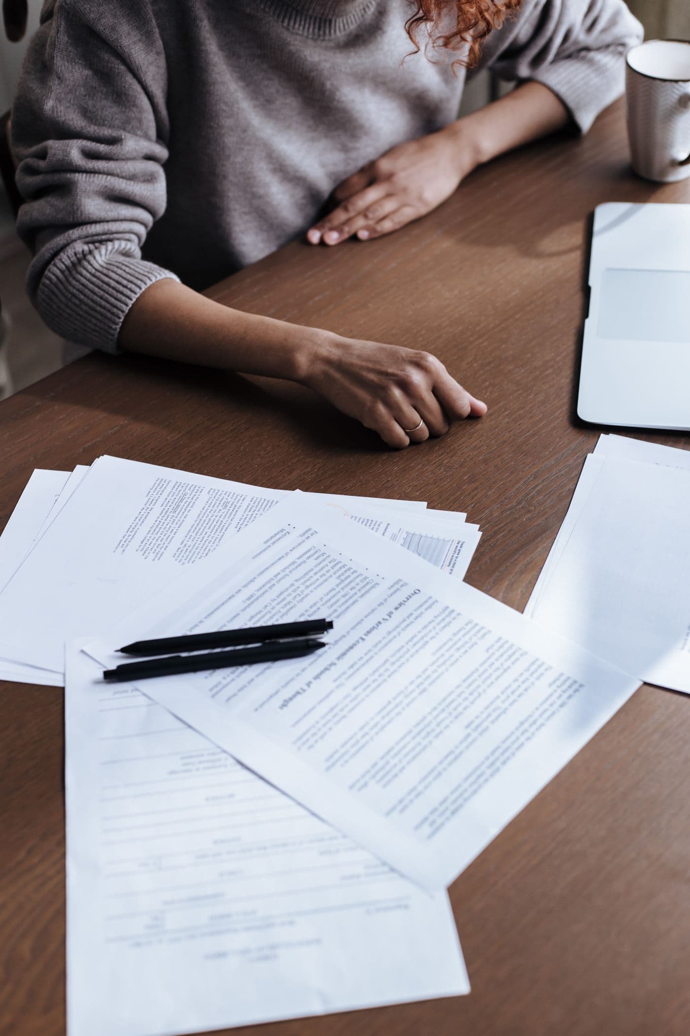 Une femme assise à son bureau passe en revue des documents.