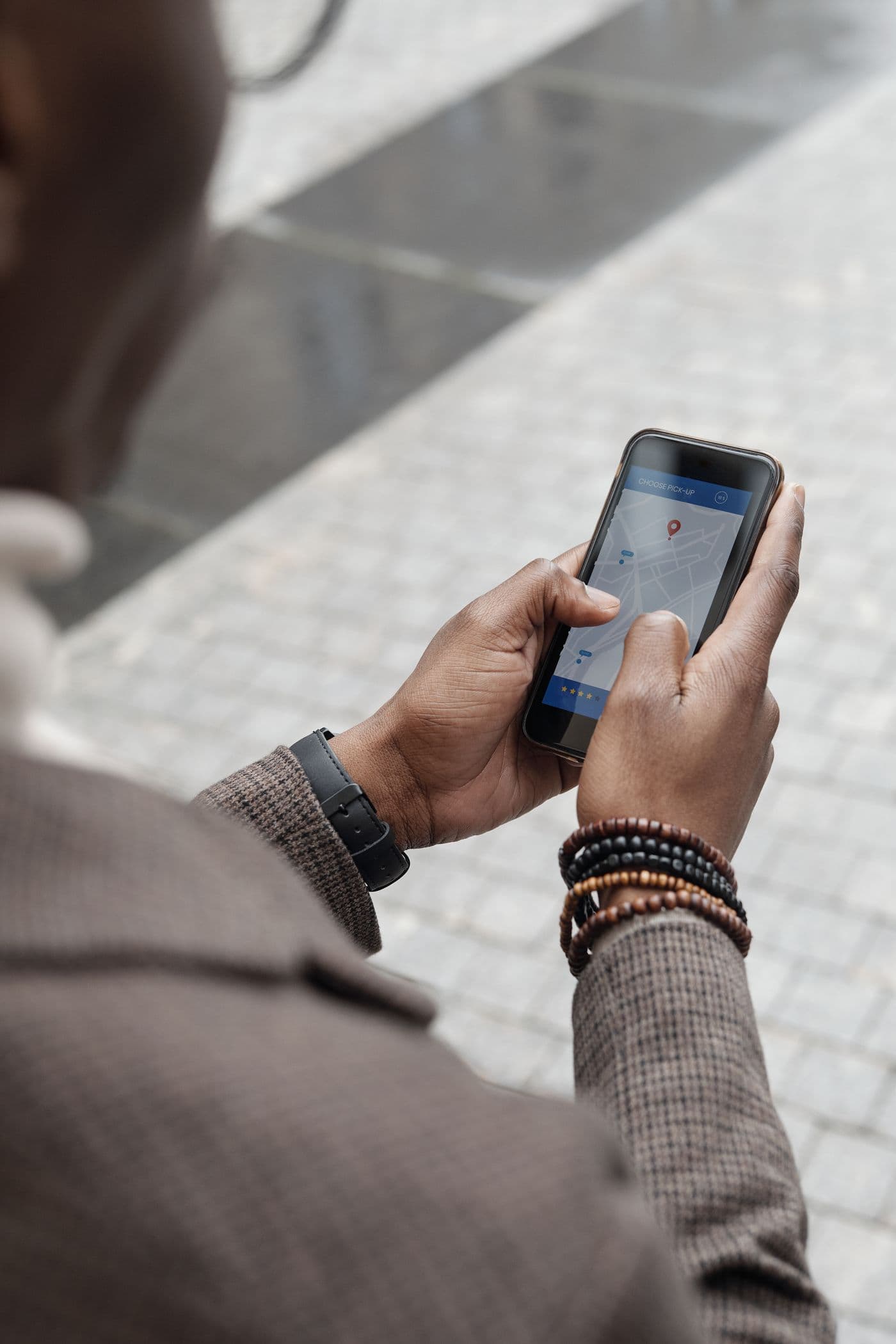 Un homme consulte un plan sur son téléphone dans une rue de la ville.